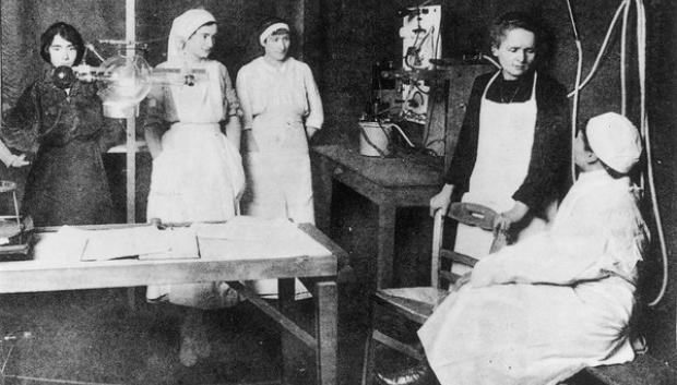 Curie explicando a un médico y un grupo de enfermeras los beneficios de la radioterapia
