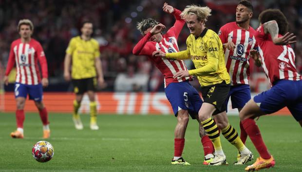 Julian Brandt disputa un balón con Rodrigo De Paul en el duelo de ida ante el Atlético de Madrid