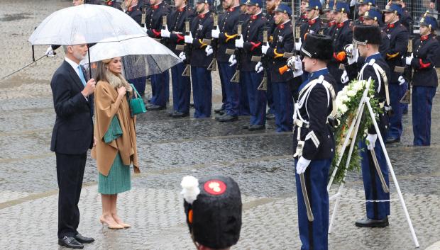 Don Felipe y Doña Letizia, con paraguas, durante la ofrenda floral al Monumento Nacional en Ámsterdam