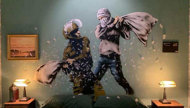 Mural de Bansky que muestra a un policía fronterizo israelí en una pelea de almohadas con un palestino
