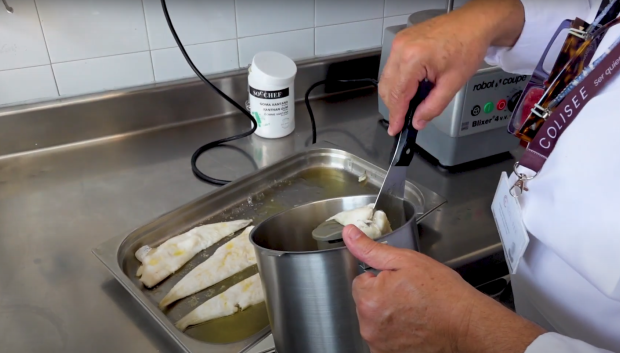 El chef introduciendo el pescado en el robot