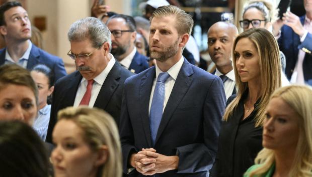 Eric Trump (C) y su mujer y copresidenta del Comité Nacional Republicano (RNC), Lara Trump, escuchan mientras el expresidente Donald Trump habla tras ser declarado culpable