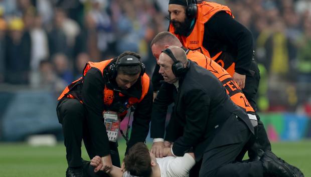 La seguridad detiene a un espontáneo durante el partido final de la Liga de Campeones