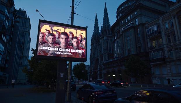 Un cartel de reclutamiento de la Brigada Azov de Ucrania durante un apagón parcial de electricidad en el centro de Kiev