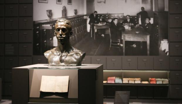 Busto de Alfonso XIII ante una fotografía histórica de la Oficina de la Guerra Europea que instaló en el Palacio Real