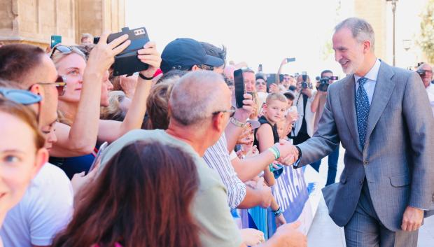 Don Felipe saludo a los numerosos vecinos y turistas congregados frente a La Almudaina