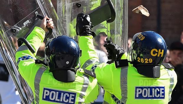 Los agentes de policía se protegen contra los manifestantes en Liverpool