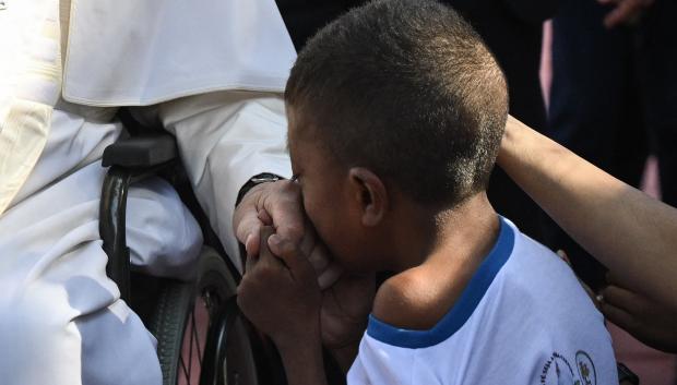 Pope Francis (L) blesses a child during his visit to the Irmas Alma School for Children with Disabilities in Dili on September 10, 2024. (Photo by Tiziana FABI / AFP)