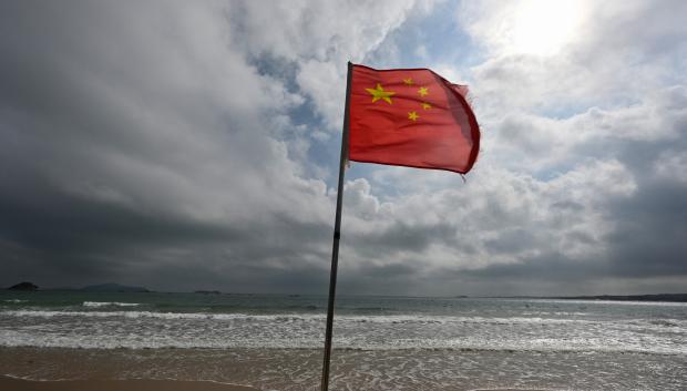 Una bandera china ondeando en una playa