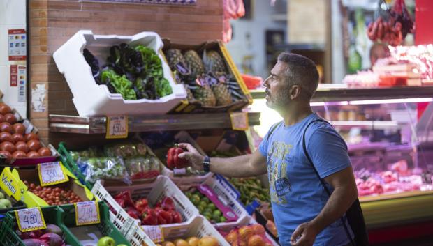 Un hombre comprando en un mercado de abastos de Triana (Sevilla)