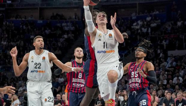 El alero croata del Real Madrid Mario Hezonja (delante) entra a canasta defendido por el senegalés Khalifa Diop (detrás), del Baskonia, durante el partido de la tercera jornada de Euroliga