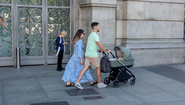 Dos personas pasean con un carrito de bebé