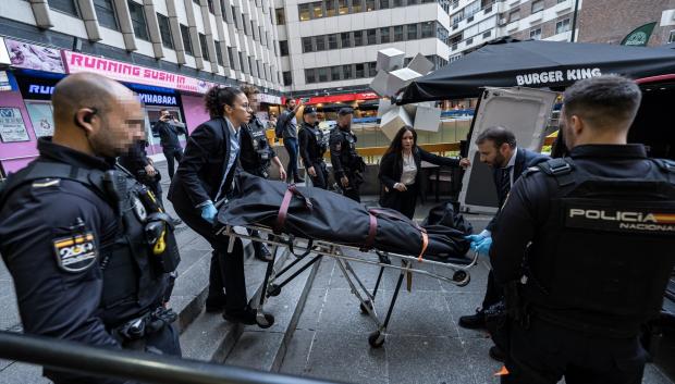 Personal de una funeraria transportan el cuerpo de la fallecida, en la Plaza de los Cubos