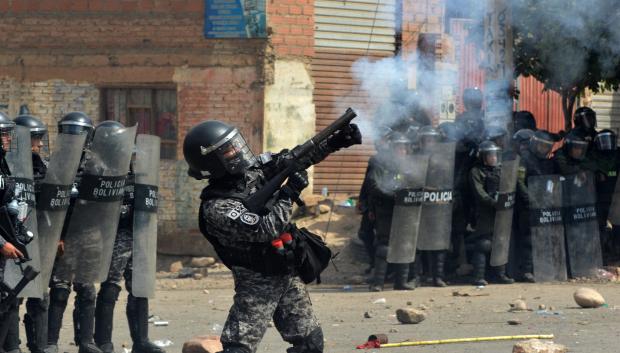 Un Policía antidisturbios dispara una lata de gas lacrimógeno contra manifestantes que apoyan al expresidente Evo Morales durante un bloqueo de carreteras en Cochabamba, departamento de Cochabamba, Bolivia