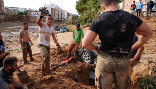 Un grupo de personas intenta desenterrar un coche en busca de víctimas. El número de desaparecidos como consecuencia de la DANA sigue siendo indeterminado