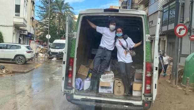 Dos voluntarios en una furgoneta con material para Valencia