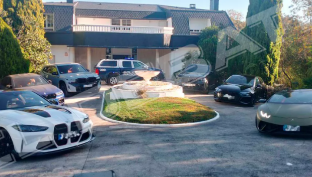 Coches de lujo y casa del jefe policial detenido, en la entrada de su chalé en Alcalá de Henares (Madrid)