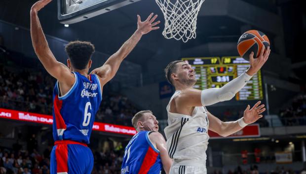 El alero croata del Real Madrid Mario Hezonja entra a canasta defendido por Elijah Bryant