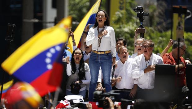 (FILES) Venezuelan opposition leader Maria Corina Machado signs the Venezuelan national anthem during a rally in Caracas on August 28, 2024. The Venezuelan Attorney General's Office opened on November 22 a new investigation against opposition leader María Corina Machado, accused of treason for conspiring with the government of Joe Biden to promote in the United States a bill to further economically isolate the Executive of Nicolás Maduro. (Photo by Pedro Rances Mattey / AFP)