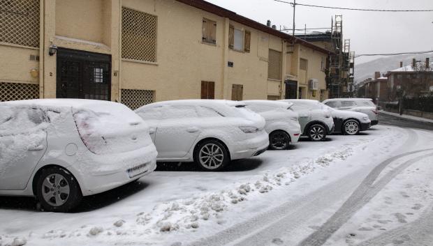 Varios coches cubiertos de nieve