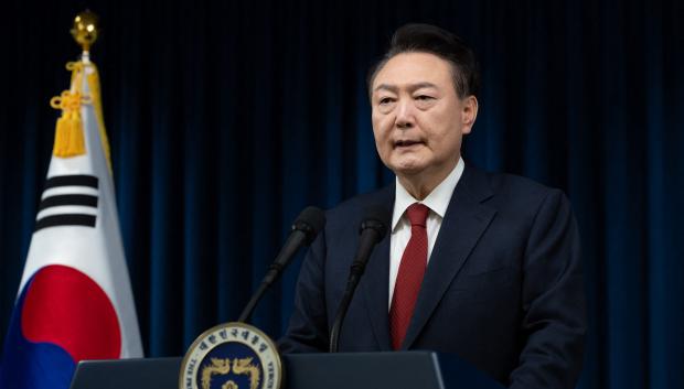This handout photo taken and released on December 7, 2024 by the South Korean Presidential Office shows South Korea's President Yoon Suk Yeol delivering an address at the Presidential Office in Seoul. South Korea's embattled President Yoon Suk Yeol stopped short of resigning on December 7 over his declaration of martial law, with a vote to impeach him hours away and mass street protests planned in Seoul. (Photo by Handout / South Korean Presidential Office / AFP) / RESTRICTED TO EDITORIAL USE - MANDATORY CREDIT "AFP PHOTO / SOUTH KOREAN PRESIDENTIAL OFFICE" - NO MARKETING NO ADVERTISING CAMPAIGNS - DISTRIBUTED AS A SERVICE TO CLIENTS / The erroneous mention[s] appearing in the metadata of this photo by Handout has been modified in AFP systems in the following manner: [2024] instead of [2023]. Please immediately remove the erroneous mention[s] from all your online services and delete it (them) from your servers. If you have been authorized by AFP to distribute it (them) to third parties, please ensure that the same actions are carried out by them. Failure to promptly comply with these instructions will entail liability on your part for any continued or post notification usage. Therefore we thank you very much for all your attention and prompt action. We are sorry for the inconvenience this notification may cause and remain at your disposal for any further information you may require.