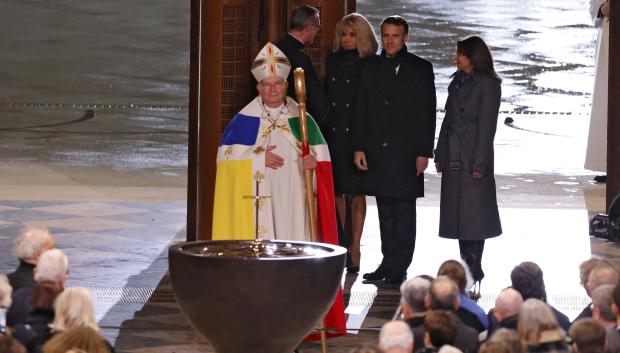 Archbishop of Paris Laurent Ulrich (C) leads French President Emmanuel Macron (2R), his wife Brigitte Macron (3R) and Mayor of Paris Anne Hidalgo (R) as they enter Notre-Dame Cathedral during a ceremony to mark the re-opening of the landmark cathedral, in central Paris, on December 7, 2024. Around 50 heads of state and government are expected in the French capital to attend the ceremony marking the rebuilding of the Gothic masterpiece five years after the 2019 fire which ravaged the world heritage landmark and toppled its spire. Some 250 companies and hundreds of experts were part of the five-year restoration project at a cost of hundreds of millions of euros. (Photo by Ludovic MARIN / POOL / AFP)