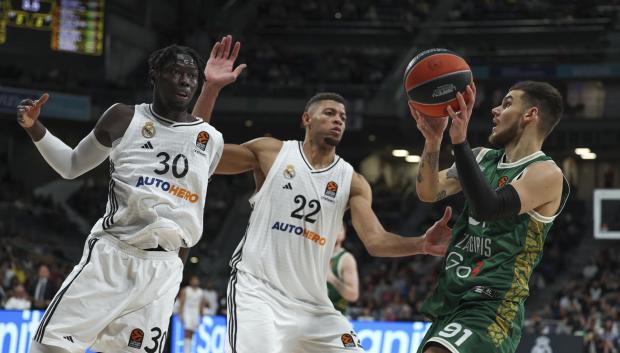 MADRID, 12/12/2024.- El escolta del Zalgiris Deividas Sirvydis (d) juega un balón ante Eddy Tavares (c) y Eli John Ndiaye, ambos del Real Madrid, durante el partido de la Euroliga de baloncesto que Real Madrid y Zalgiris Kaunas disputan este jueves en el WiZink Center. EFE/Kiko Huesca