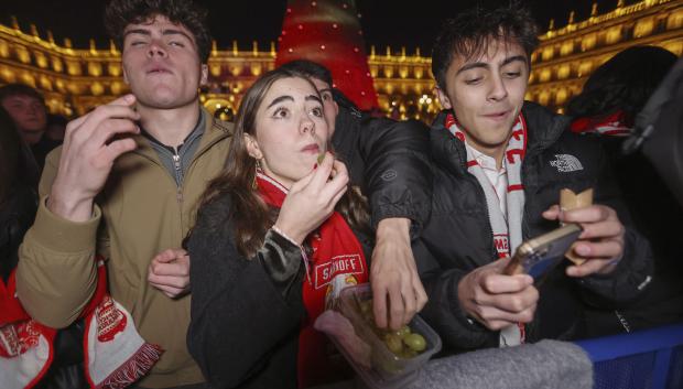 Varios jóvenes comen las tradicionales 12 gominolas en la Plaza Mayor de Salamanca