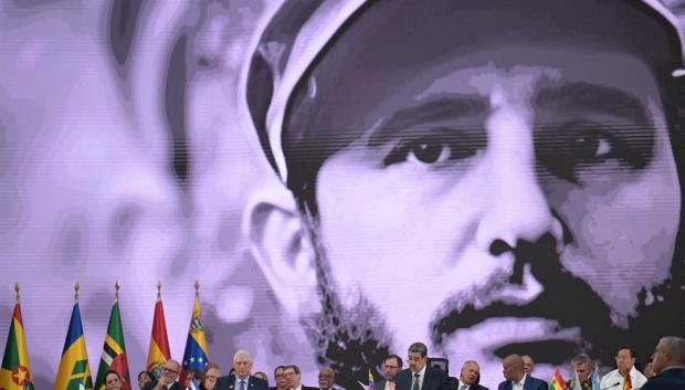 A photograph of Cuban late leader Fidel Castro is projected on a screen as Venezuela's President Nicolas Maduro speaks during the opening session of the XXIV ALBA-TCP Summit in Caracas on December 14, 2024. The Bolivarian Alliance for the Peoples of Our America (ALBA) celebrates its 20th anniversary in a regional context where its influence is increasingly diminishing. The summit, originally planned in Havana where the founding document was signed, was moved to the Venezuelan capital at the peak of an economic crisis that is hitting Cuba. (Photo by JUAN BARRETO / AFP)