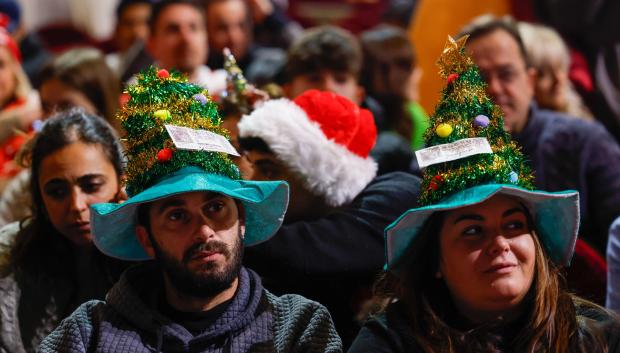 Asistentes aguardan el inicio del sorteo de la Lotería de Navidad este domingo en el Teatro Real, en Madrid