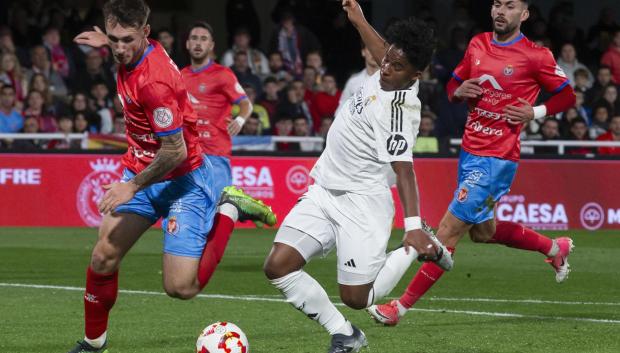 El delantero brasileño del Real Madrid Endrick (c) controla el balón ante el jugador de la Deportiva Minera Fran Molina (i)