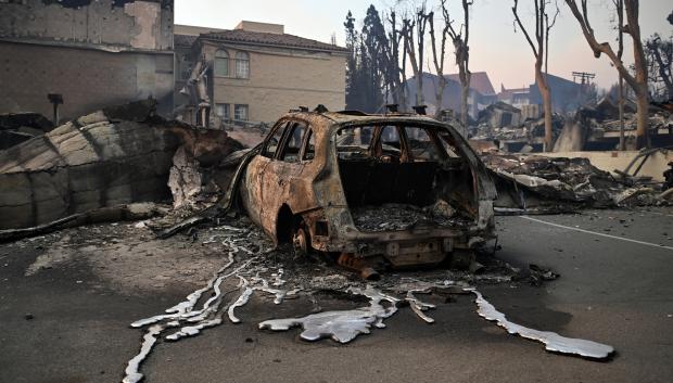 El metal derretido de un vehículo carbonizado se ve en el pavimento después del paso del incendio Palisades en Pacific Palisades, California