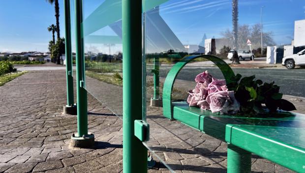 Un ramo de flores en una parada de autobús de Gerena (Sevilla), en el entorno donde ayer fue apuñalado mortalmente un menor de 17 años a la salida de su instituto