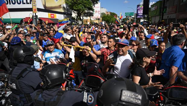 Manifestantes bloquean a miembros de la policía después de que la líder opositora venezolana María Corina Machado pronunciara un discurso durante la protesta convocada por la oposición en Caracas