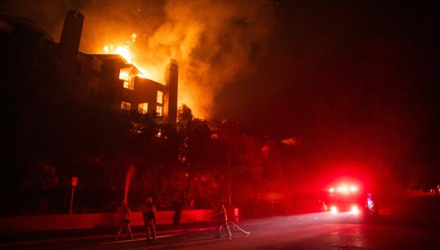 Las llamas del incendio Palisades queman un edificio residencial en Sunset Boulevard en medio de una poderosa tormenta de viento