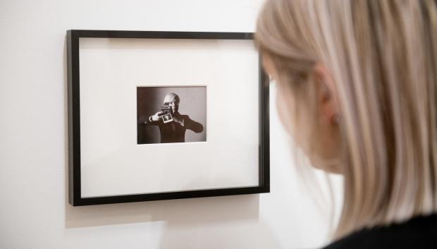 Una mujer observa una de sus imágenes en una exposición del fotógrafo en 2018