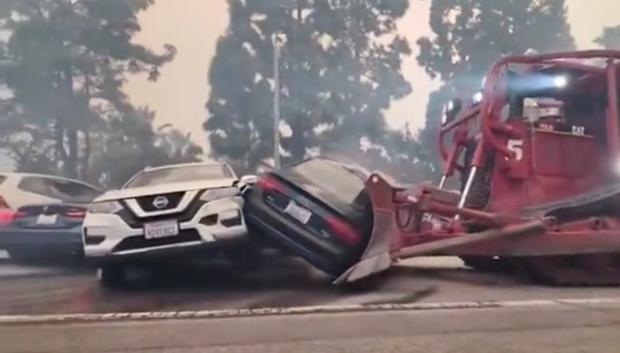 Bulldozer moviendo los coches abandonados para liberar las calles