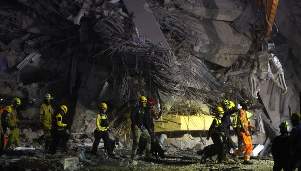 Rescatistas y perros realizan una operación de búsqueda en el lugar del derrumbe de un edificio tras un terremoto en Bangkok