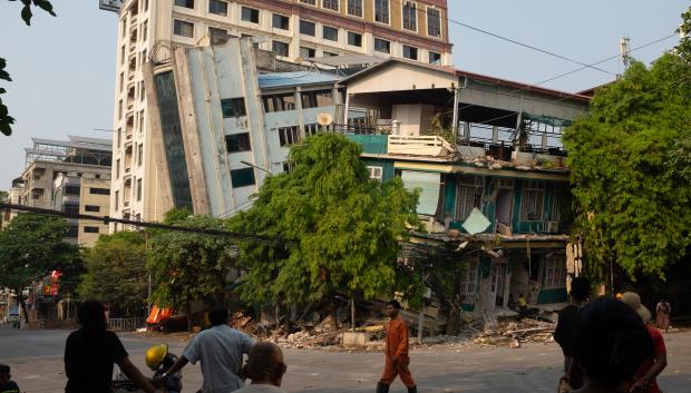 Rescatistas caminan frente a un edificio dañado tras un terremoto en Mandalay