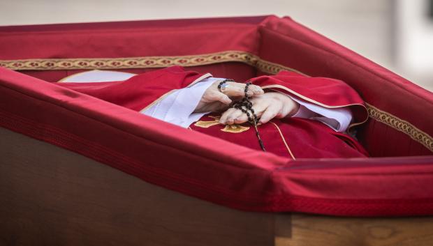 El Papa, dentro del ataúd forrado de rojo y con el rosario en las manos