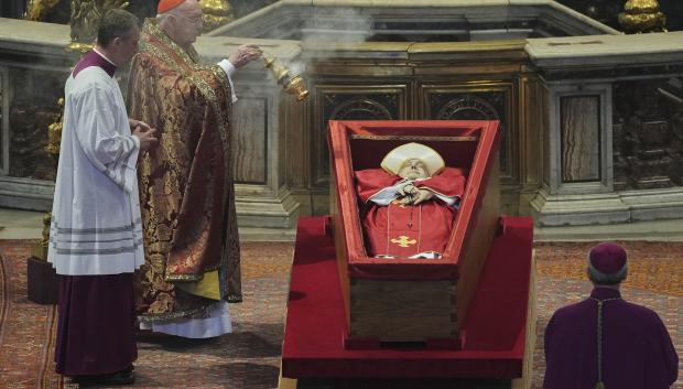 El cardenal camarlengo incensando el féretro