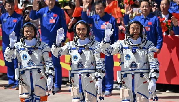 Los astronautas de la misión espacial china Shenzhou-20, Wang Jie, Chen Zhongrui y Chen Dong, saludan durante una ceremonia de despedida