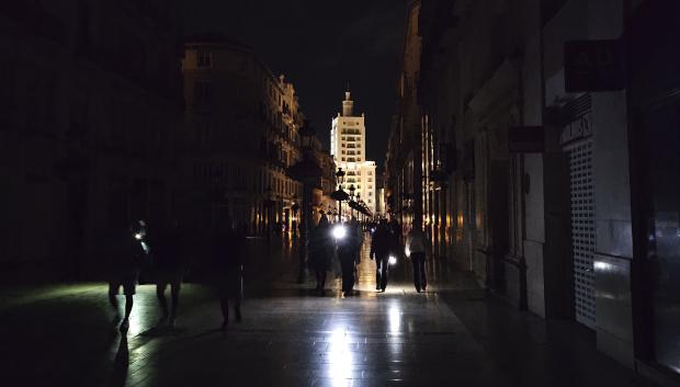 Vista de la céntrica calle Larios de Málaga, una de las más reconocidas de España, a oscuras durante la noche del lunes durante el apagón eléctrico