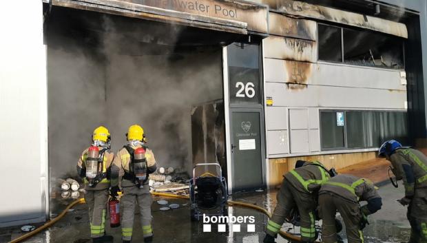 Los bomberos actuando en la fábrica incendiada