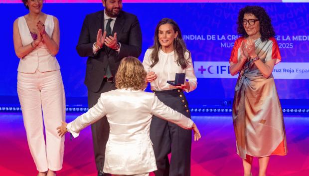 La reina Letizia (c), acompañada por el presidente de la Comunidad de Murcia Fernando López Miras 2(i), la presidenta de la Cruz Roja nacional María del Mar Pageo (d), entrega el galardón de la medalla de oro de la Cruz Roja 2025 a la periodista Almudena Ariza (espaldas), durante el acto de entrega de Distinciones 2025 de Cruz Roja Española, este miércoles en el Teatro Romea de Murcia, con motivo del Día Internacional de Cruz Roja. EFE/Marcial Guillén