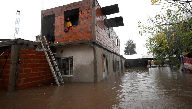 Personas esperan ser rescatadas de su casa inundada tras las fuertes lluvias en Campana, provincia de Buenos Aires