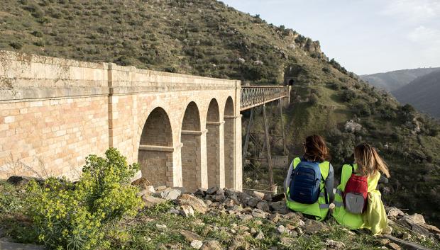 Senderistas junto a uno de los diez puentes de la ruta.