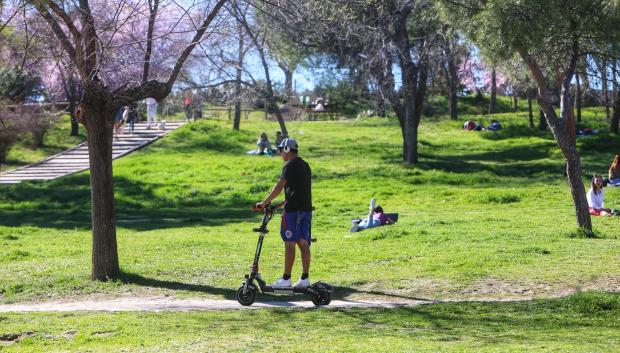 Un hombre montando en patinete en la Casa de Campo