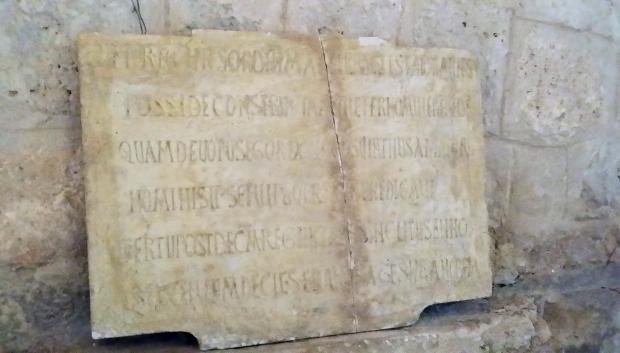 Lápida junto al ábside que certifica el origen de la iglesia.