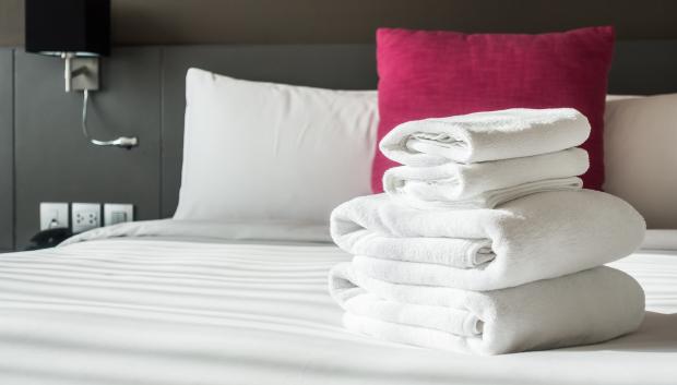 Toallas de hotel dobladas sobre la cama.
